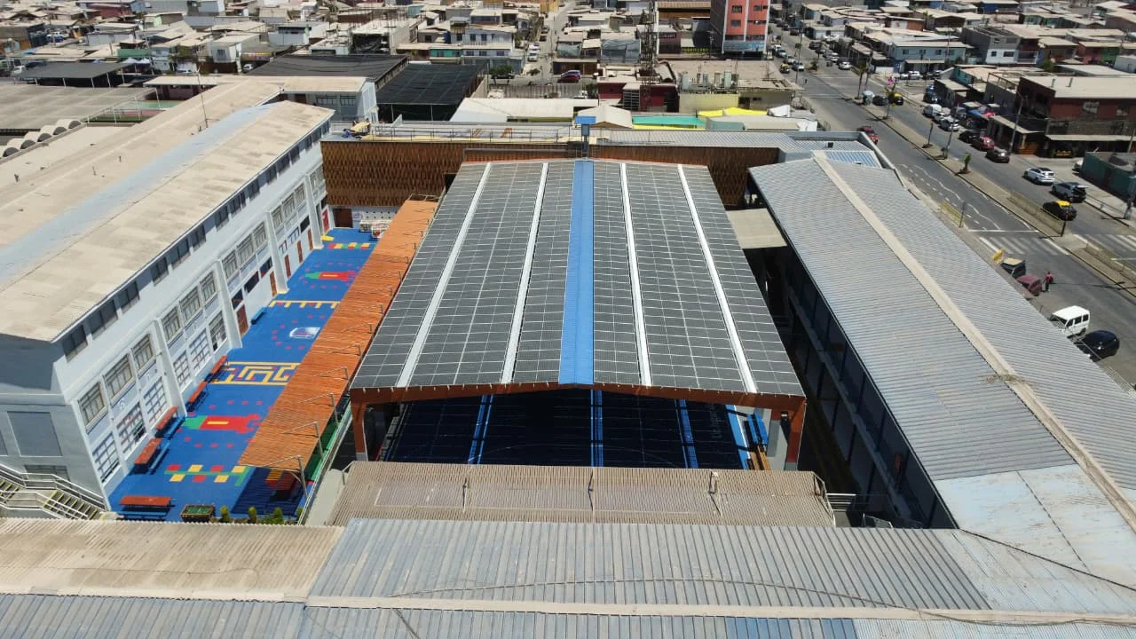 Vista aérea de una instalación fotovoltaica sobre un establecimiento educacional.